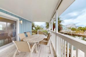 a patio with a table and chairs on a porch at Flood Reef Getaway in Pensacola