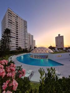un immeuble avec une piscine devant un immeuble dans l'établissement Apartamento frente ao mar Punta del Este, à Punta del Este