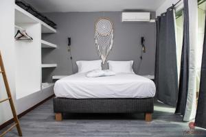 a bedroom with a bed with white sheets at Appartement moderne à la Marina du Gosier in Le Gosier