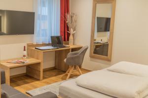 um quarto com uma cama e uma escrivaninha com um computador em M-A-S-Hotel em Estugarda