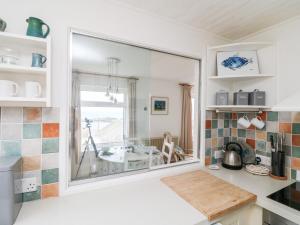 uma cozinha com um grande espelho na parede em Wootton Gray em Mousehole