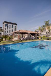 una gran piscina azul con un edificio en el fondo en Hotel Malibu, en Guadalajara