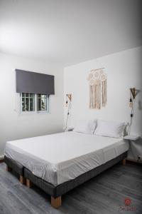 a white bedroom with a large white bed in it at Appartement moderne à la Marina du Gosier in Le Gosier