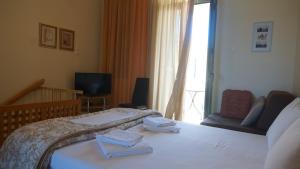 1 dormitorio con 1 cama con 2 toallas en Annas Sea & City, en Palaiochóra