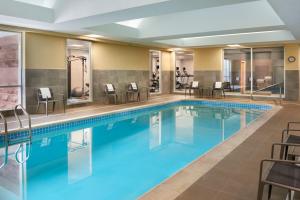 密西沙加的住宿－多倫多米西索加/梅多維爾萬怡酒店，游泳池位于酒店客房内,配有桌椅