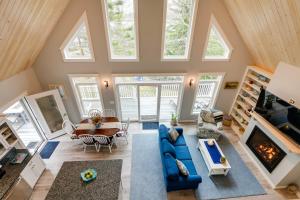 - un salon avec un canapé bleu et une table dans l'établissement Oceanfront Prospect Harbor House with Deck and View, à Prospect Harbor