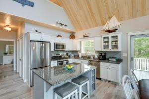cocina con armarios blancos y encimera de granito en Oceanfront Prospect Harbor House with Deck, View, en Prospect Harbor