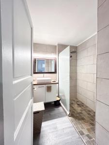 La salle de bains est pourvue d'une douche et d'un lavabo. dans l'établissement Appartement moderne à la Marina du Gosier, au Gosier
