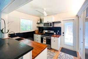 uma cozinha com armários brancos e um forno com placa de fogão em Northwood Charmer em West Palm Beach