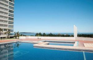 une grande piscine à côté d'un grand bâtiment dans l'établissement Apartamento frente ao mar Punta del Este, à Punta del Este 23 autres photos