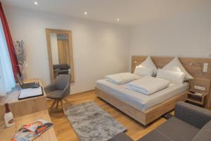 um quarto com uma cama, uma cadeira e uma mesa em M-A-S-Hotel em Estugarda