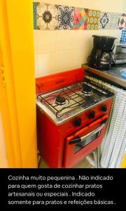 a red stove top oven in a kitchen at Studio perto de tudo vista Mar Flamengo in Rio de Janeiro