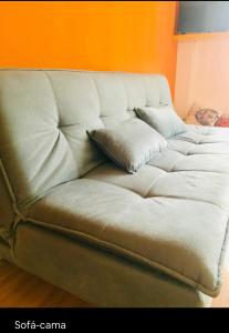 a couch with a pillow on it in a room at Studio perto de tudo vista Mar Flamengo in Rio de Janeiro