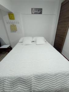 a large white bed with two pillows on it at apartaestudio con 2 camas cerca al centro y parqueadero GRATIS in Popayan