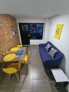 a living room with a table and a blue couch at Apartaestudio con 2 camas cerca al centro y parqueadero GRATIS in Popayan