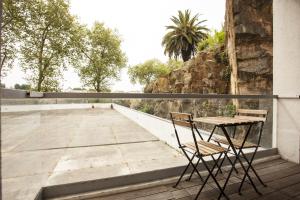 una mesa y 2 sillas sentadas en un balcón en Casa do Sol en Oporto