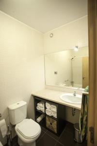 a bathroom with a toilet and a sink and a mirror at Casa do Sol in Porto