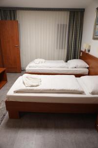 two beds in a hotel room withskirts at M-A-S-Hotel in Stuttgart