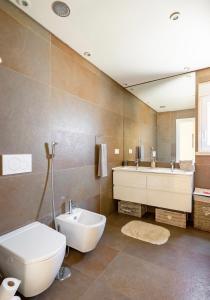 a bathroom with a toilet and a sink and a tub at Modern Double Room with Private Balcony in Montijo