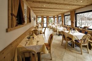 un ristorante con tavoli, sedie e finestre di Hotel Am Fels a Senales