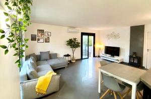 a living room with a couch and a table at BARCARESA-Villa Flamants Roses in Le Barcarès