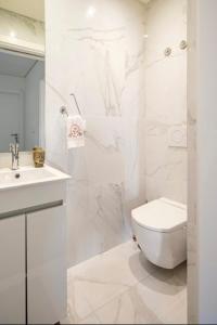 a white bathroom with a toilet and a sink at Modern Double Room with Private Balcony in Montijo
