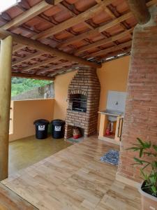 uma sala de estar com lareira de tijolos numa casa em Chácara Picapau Amarelo em Socorro
