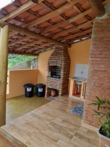 a living room with a brick fireplace in a house at Chácara do Picapau Amarelo in Socorro