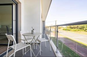 a patio with a table and chairs on a balcony at Modern Twin Room with a balcony in Montijo