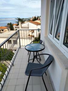 a table and chairs on a balcony with a view of the ocean at SilvioDino SOBE in Crikvenica +8 photos