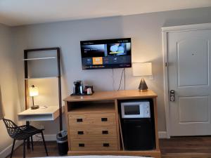 a room with a microwave and a tv on a wall at Bridge Street Inn in Baker City