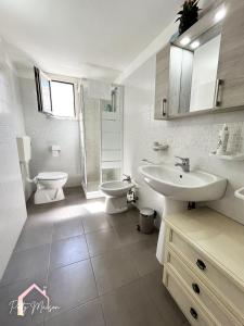 a white bathroom with a sink and a toilet at Patty Maison - Large & New Central Apartment in Bari