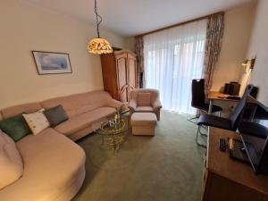 a living room with a couch and a tv at Haus Ekke Nekkepenn II, Whg C1 in Wyk auf Föhr