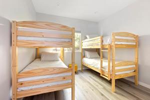 Adorable 3 bedroom with Jacuzzi & more في لوس أنجلوس: سريرين بطابقين في غرفة صغيرة مع أرضيات خشبية