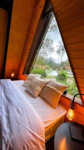 a bed with pillows in a room with a window at Cabana da Mata in Teresópolis