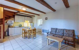 Castelnau-de-MandaillesにあるCozy Home In Castelnau D Mandailles With Kitchenのリビングルーム(ソファ、テーブル付)、キッチンが備わります。