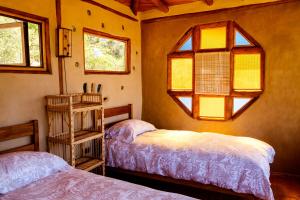 1 dormitorio con 2 camas y ventana en Swiss Eco Lodge La Linda Loma - Olmué, en Olmué