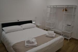 Un dormitorio con una cama blanca con toallas. en Nel Cuore del Borgo "Superior", en Vitorchiano