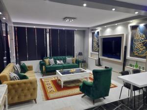 uma sala de estar com mobiliário verde e uma televisão de ecrã plano em Beylikduzu Gunluk Kiralik Daire em Esenyurt