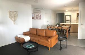 a living room with a couch and a dining room at Unit 3 - Manly Boutique Apartments in Brisbane
