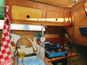 a kitchen with a sink and a pot on a stove at Relax on the canals Cozy Sailboat for 3 people in Groningen