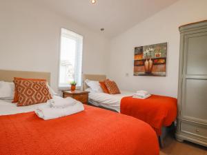 um quarto com 2 camas com lençóis laranja em 8 Horizon View em Liskeard