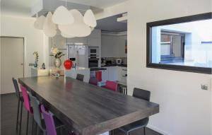 eine Küche und ein Esszimmer mit einem Holztisch und Stühlen in der Unterkunft Nice Home In Lons With Kitchen in Lons