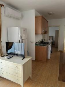 a kitchen with a refrigerator and a table with a tv at Kaleici Aparts Antalya in Antalya