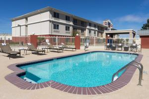 a swimming pool with chairs and a building in the background at Fairfield Inn & Suites by Marriott Odessa in Odessa