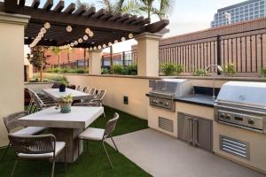 an outdoor patio with tables and chairs and a grill at Residence Inn Los Angeles Glendale in Glendale
