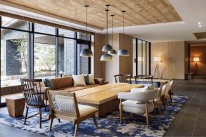 a dining room and living room with a wooden table and chairs at Fairfield by Marriott Hiroshima Sera in Sera