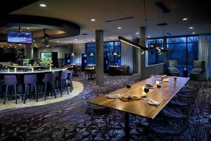 una sala da pranzo con tavolo e bar di Courtyard by Marriott Corvallis a Corvallis