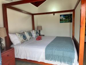 a bedroom with a large bed with a wooden frame at Cozy Oceanfront Room Hidden Treasure in Treasure Beach