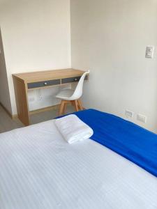 Schlafzimmer mit einem Bett, einem Schreibtisch und einem Stuhl in der Unterkunft Hermoso apto en Chapinero in Bogotá